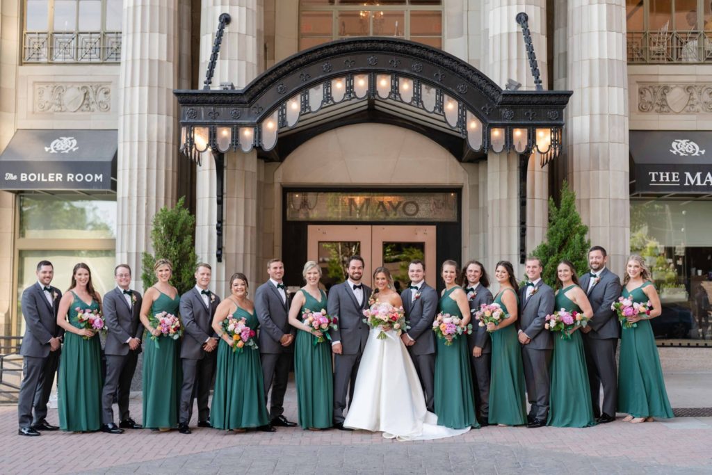 Bridal party with bridesmaids in emerald green dresses and groomsmen in grey suits