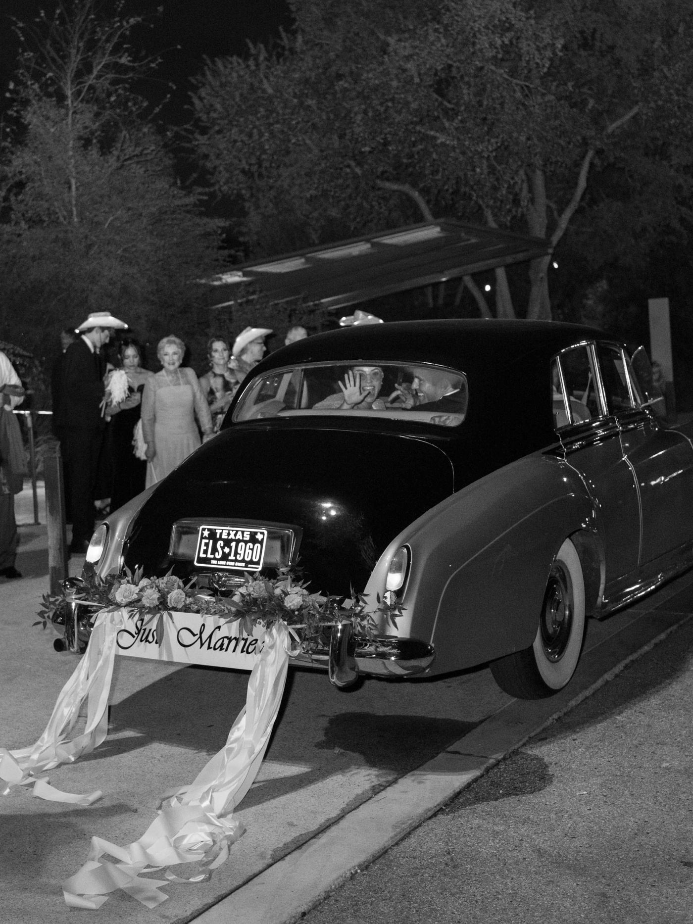 Vintage limousine with a Just Married bumper leaving a Texas wedding