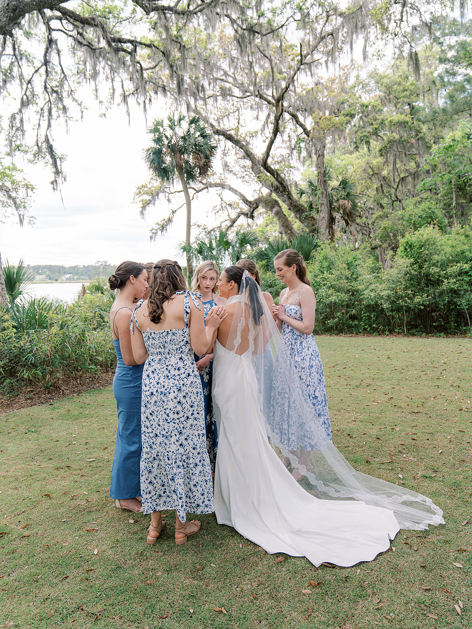 bridesmaids in soft blue hugging on wedding day