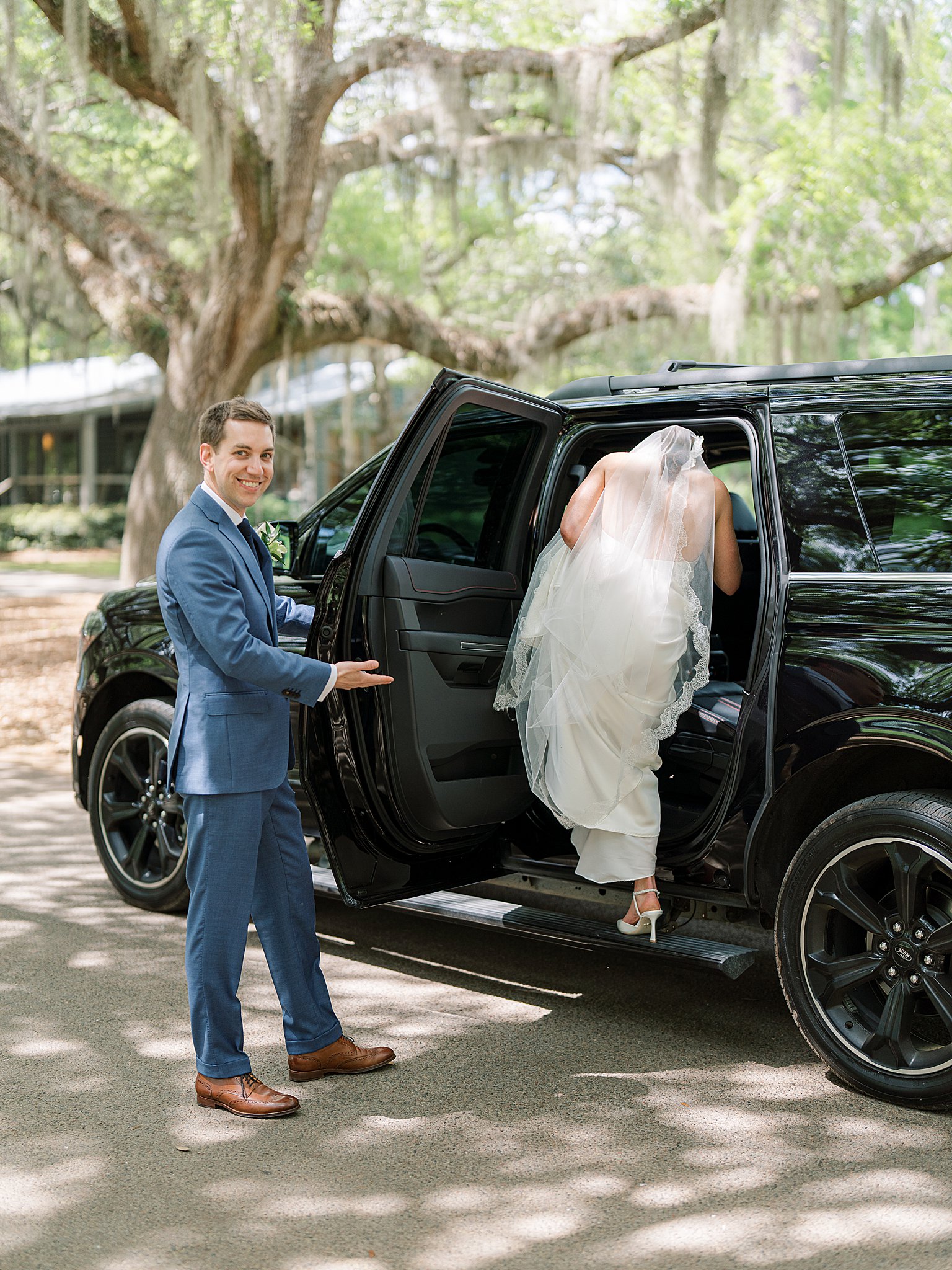 groom helping bride into car