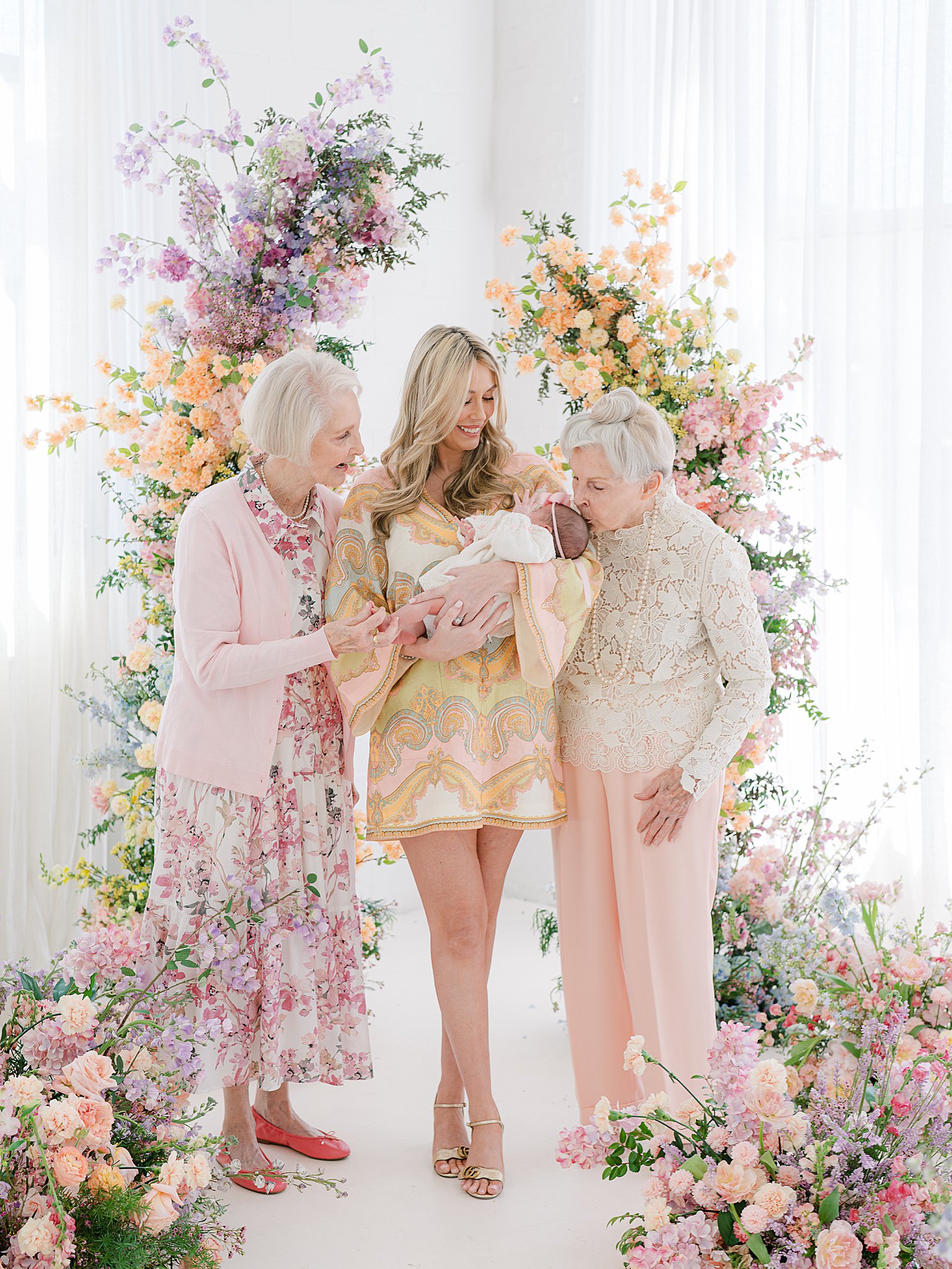 Grandmother kissing great granddaughter on the head