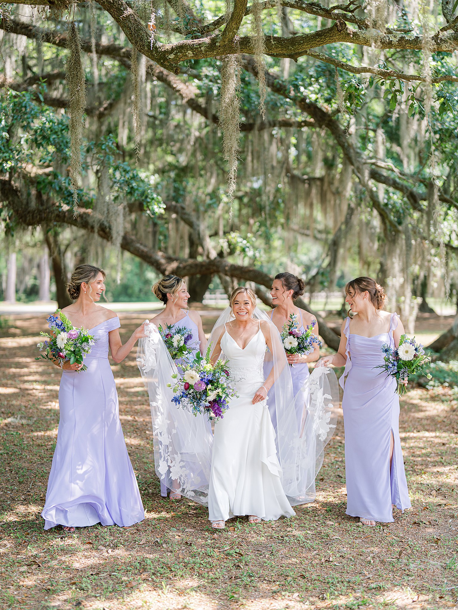 vibrant spring island wedding photo of bridesmaids walking under spanish moss trees