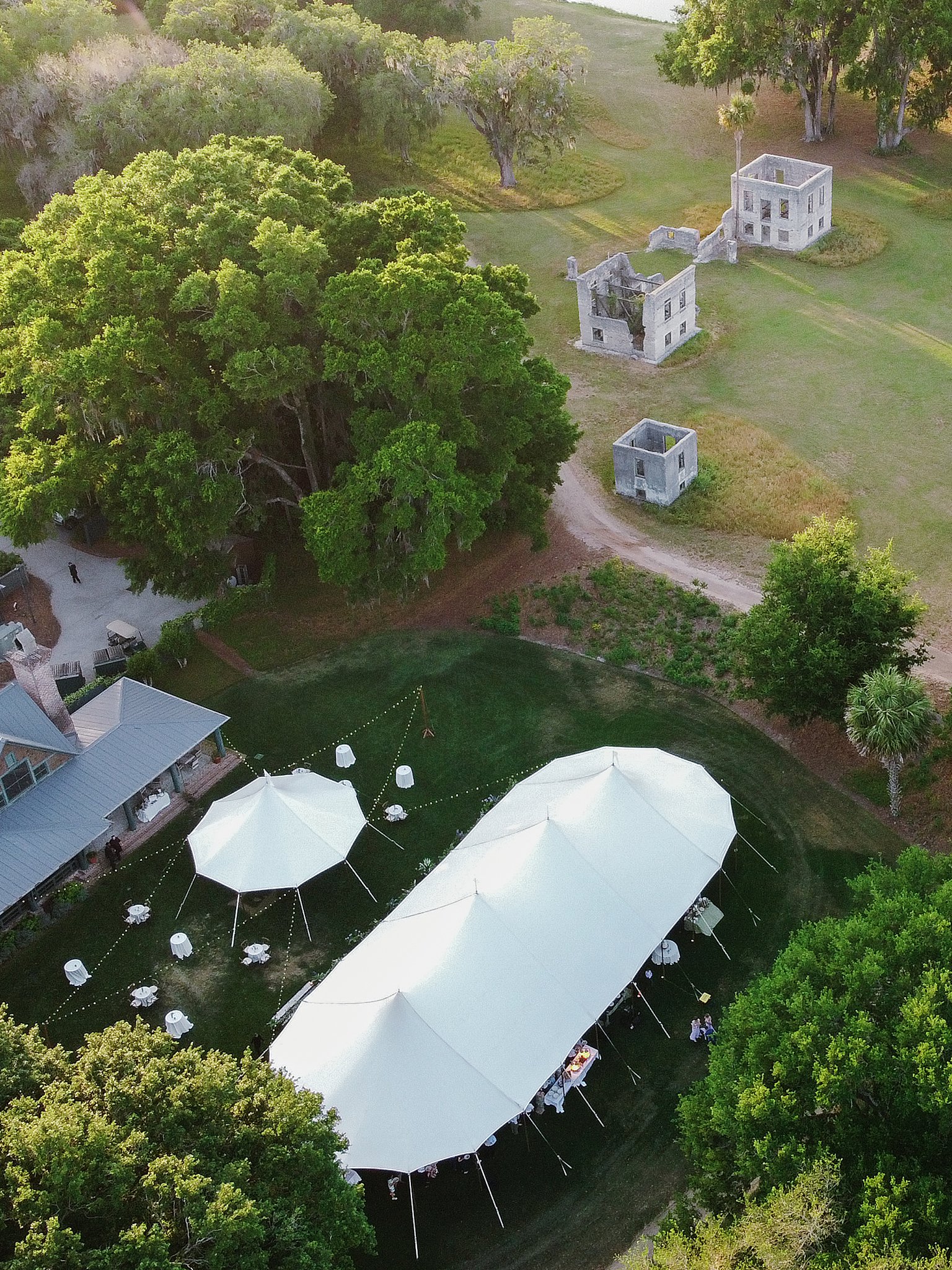 Tented wedding reception by the marsh with candlelight and greenery captured by destination wedding photographer in South Carolina.