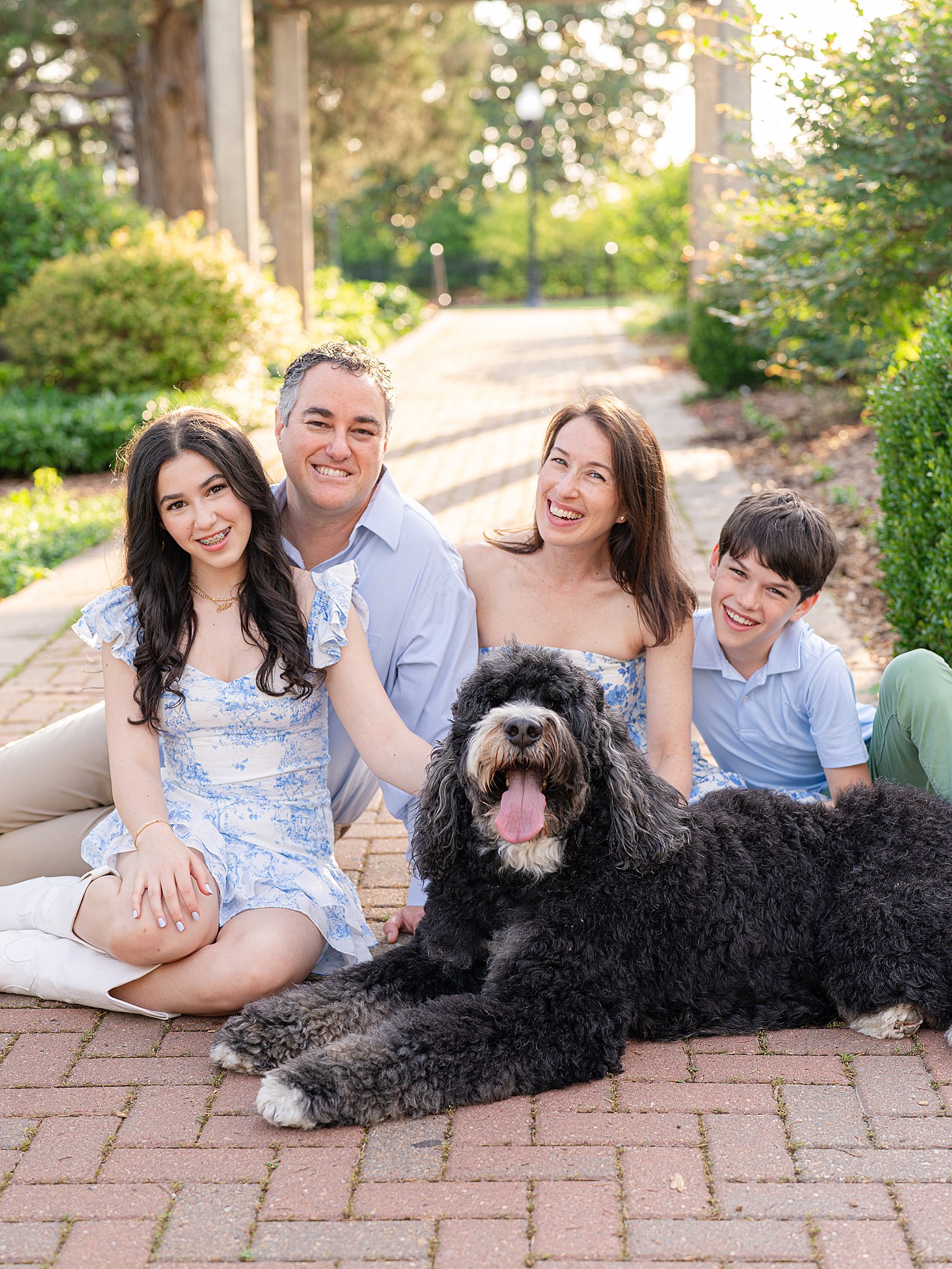 Family posing with their dog during outdoor photos in Tulsa, Oklahoma.